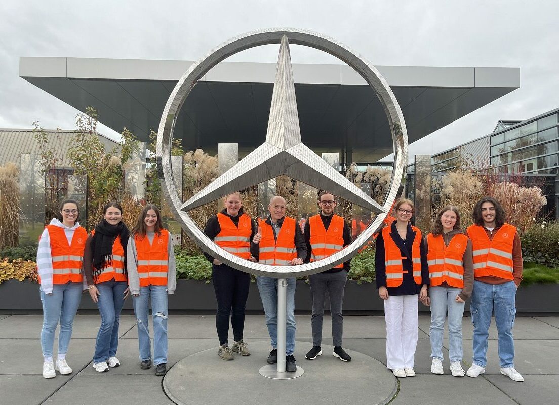 Portrait der Teilnehmenden der Exkursion vor dem Mercedes-Benz Werk in Sindelfingen